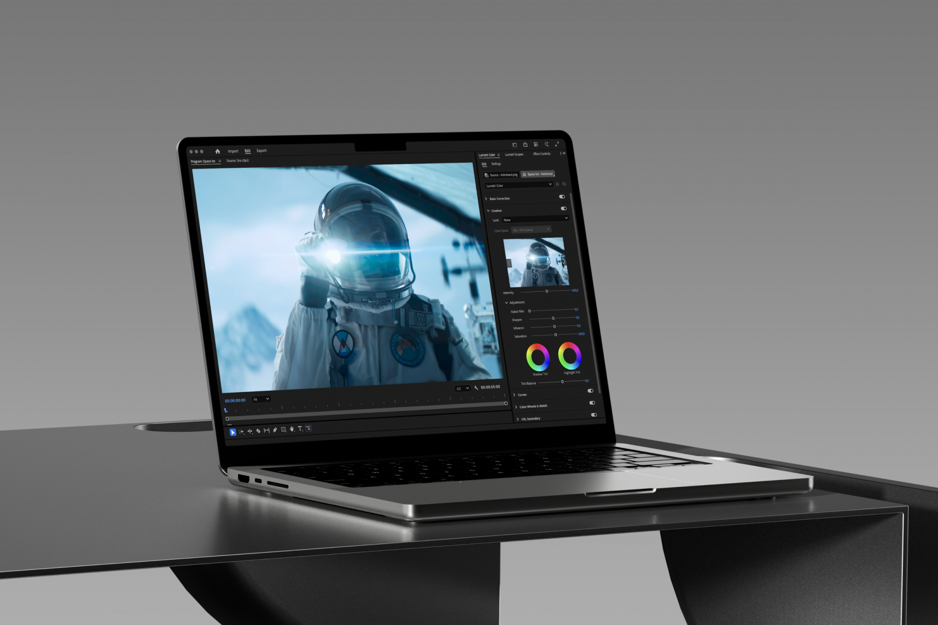 A MacBook with video editing software on a table
